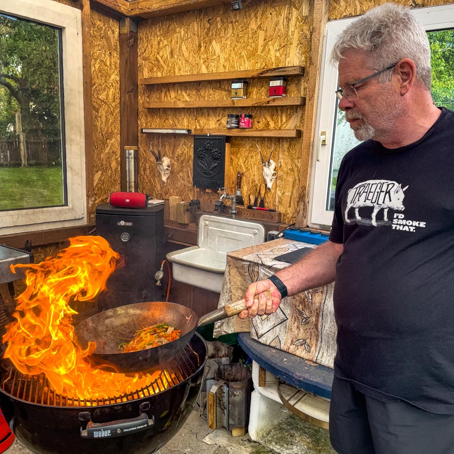 Mit dem Wok auf dem Hoözkohlegrill grillen